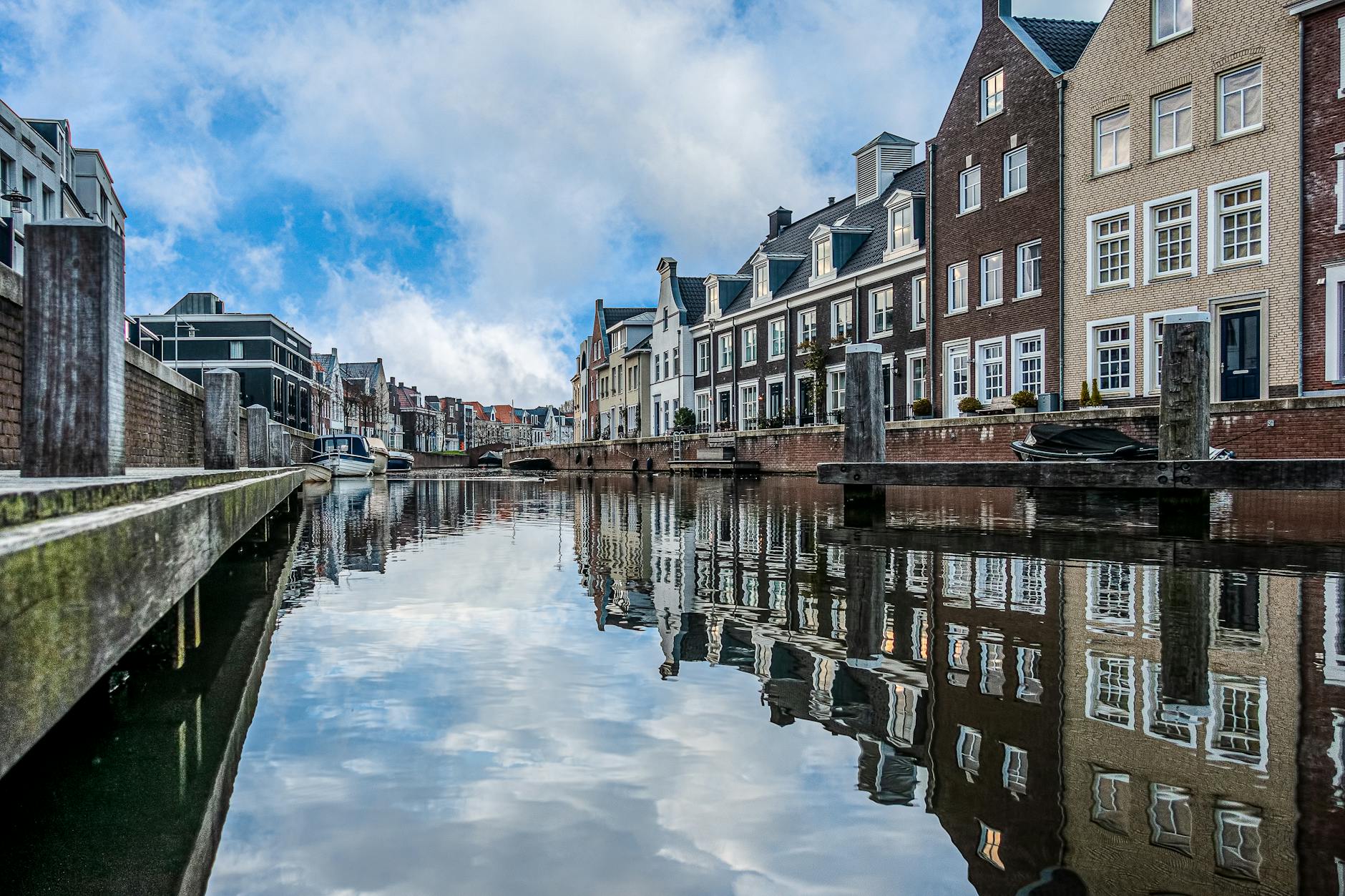 Zabytkowe kamienice odbijające się w spokojnym kanale w holenderskim miasteczku