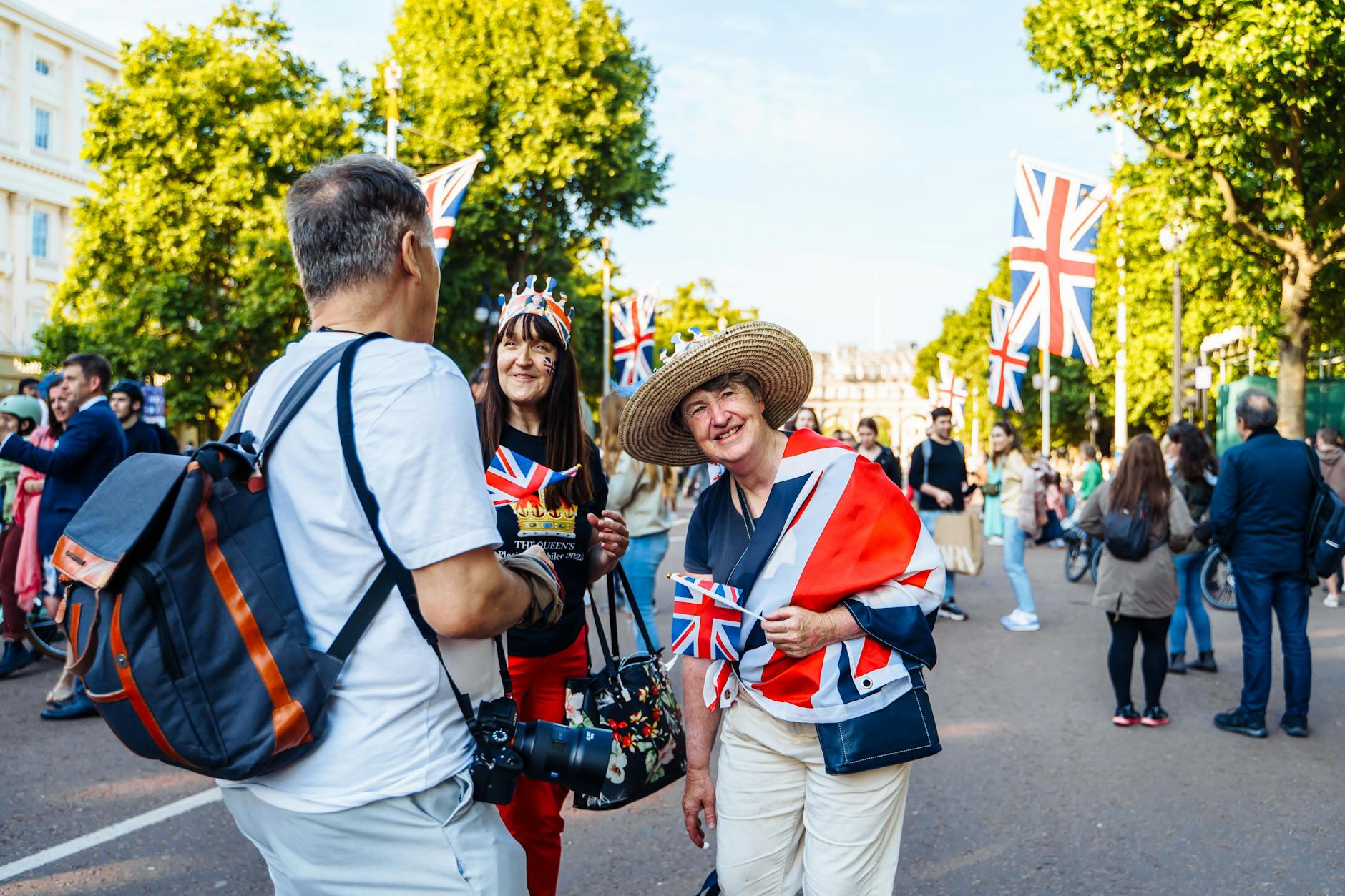 Tłum w centrum Londynu świętujący na ulicy pod flagami Union Jack