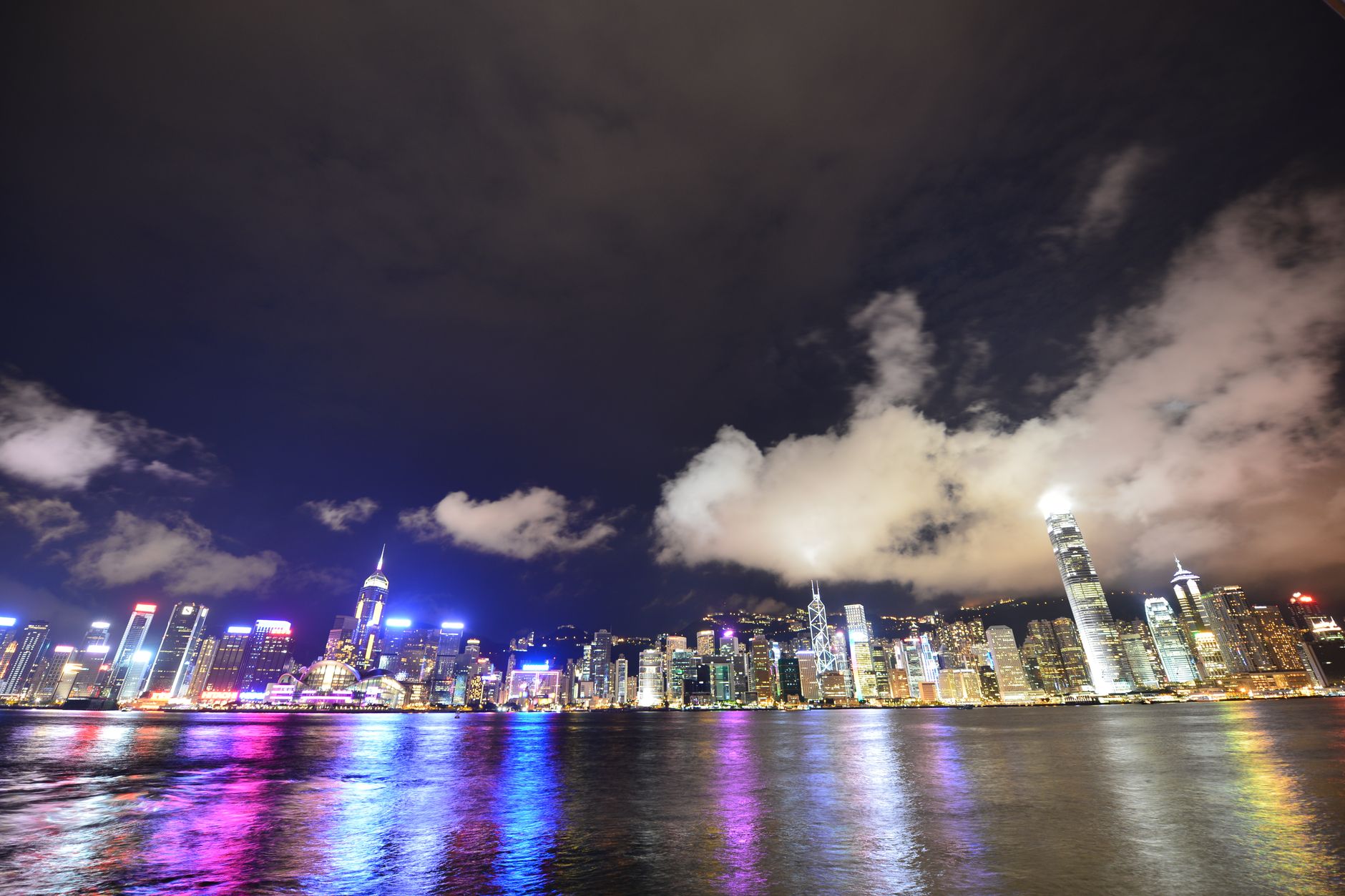 Nocna panorama rozświetlonego Hongkongu odbijająca się w Victoria Harbour